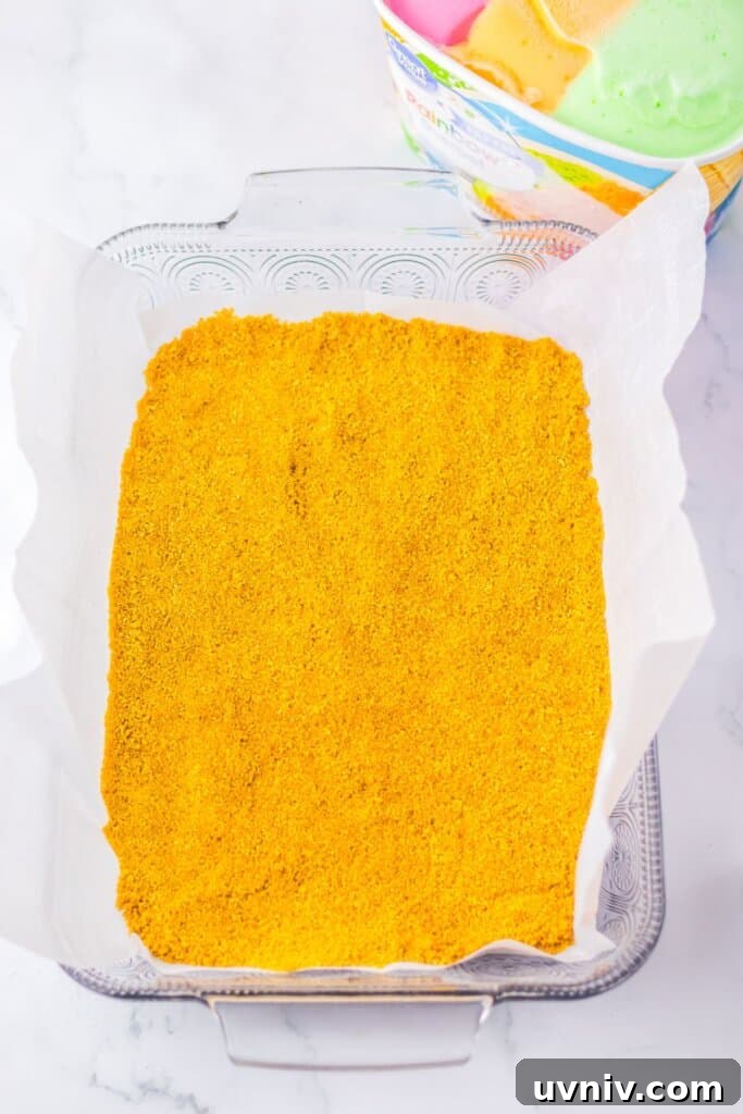 No-Bake Rainbow Sherbet Dessert Bars 5 Graham cracker crust pressed into a glass baking dish.