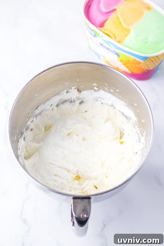 No-Bake Rainbow Sherbet Dessert Bars 6 Whipped cream in a stainless steel mixing bowl.