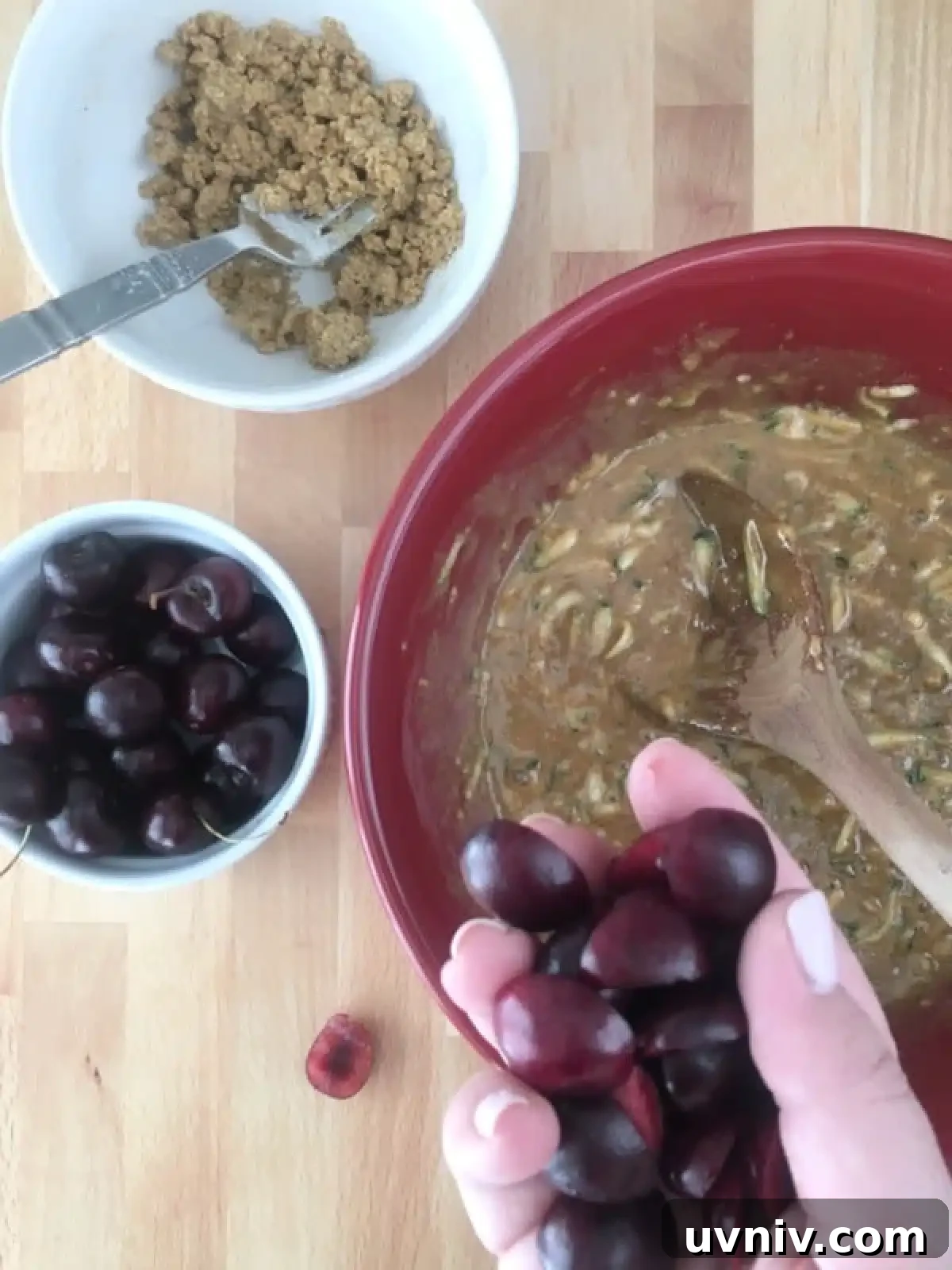 Cherry Zucchini Crumb Muffins @spabettie #glutenfree #vegan How to make cherry zucchini muffins: bowl of muffin batter, chopped cherries in a hand, crumb topping in a smaller bowl.