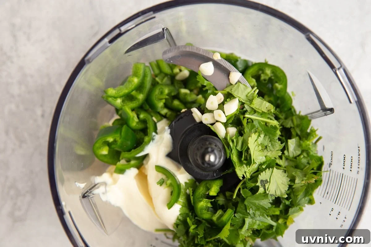 Peruvian Roast Chicken with Aji Verde Green Sauce Recipe 3 Food processor full of mayonnaise, cilantro, jalapeno, and fresh garlic to make aji verde sauce.