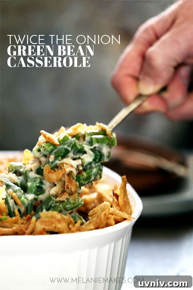 Twice the Onion Green Bean Casserole A scoop of Twice the Onion Green Bean Casserole is being lifted out of a white casserole dish.