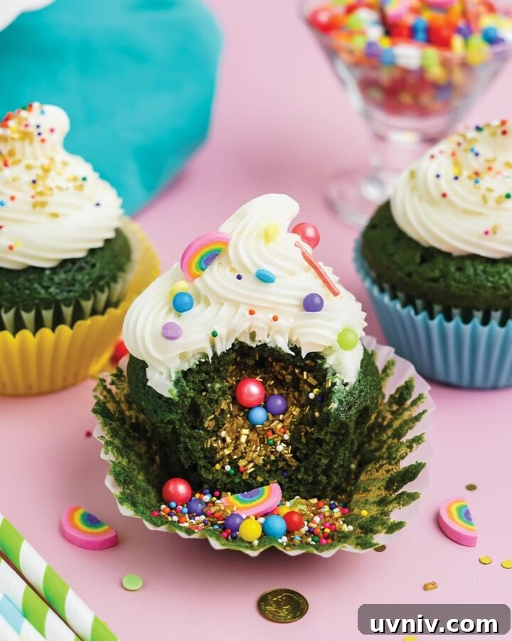 St Patrick's Day cupcakes missing a bite to show sprinkles spilling out of inside.