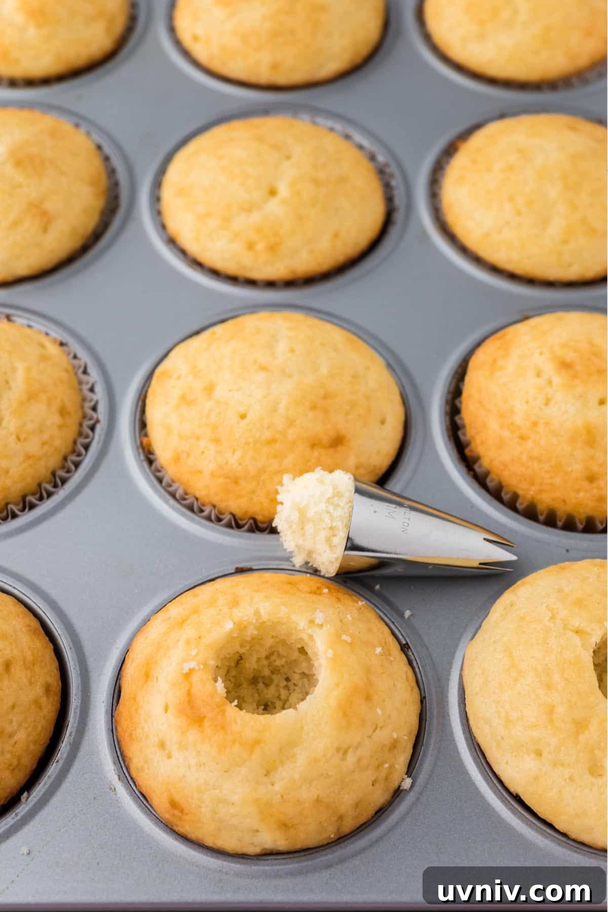 Making a hole in the cupcake to add the strawberry.