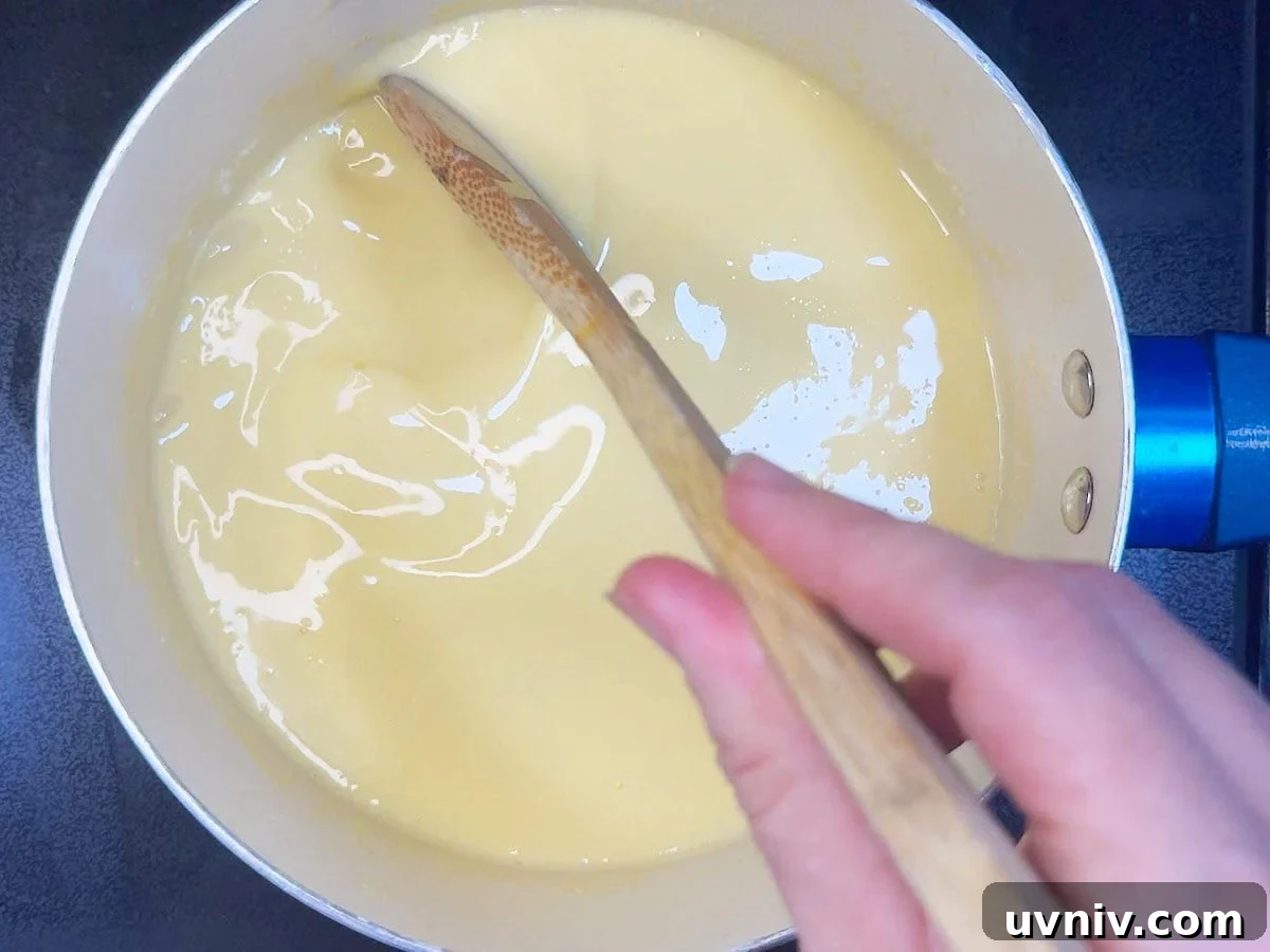 White Chocolate Cranberry Bread Pudding Recipe for Holidays 13 Stirring the cream and tempered egg yolks until thick.
