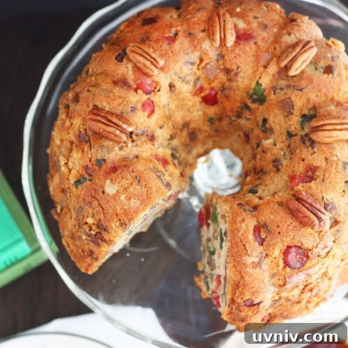 White fruitcake on a glass cake pedestal.