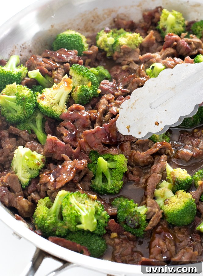 Beef and Broccoli | chefsavvy.com stir fried beef and broccoli in a large skillet with tongs