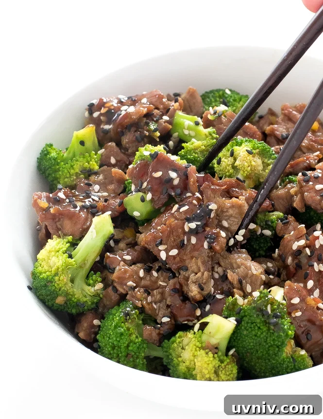 Skirt Steak Chinese Beef | chefsavvy.com author using chopsticks to pick up beef and broccoli in bowl