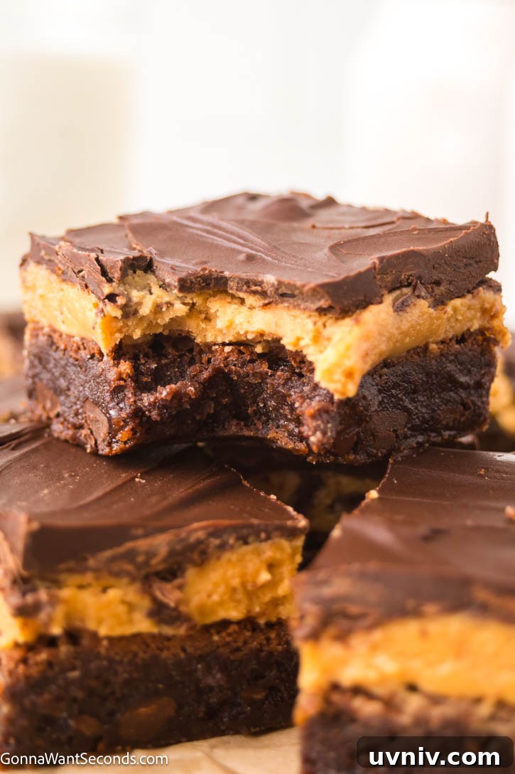 Ultra-fudgy Buckeye Brownies with a creamy peanut butter layer + glossy chocolate topping. A Nostalgic chocolate-PB dessert everyone loves. #buckeyerecipes #brownies Slices of Buckeye Brownies with a creamy peanut butter layer and glossy chocolate topping