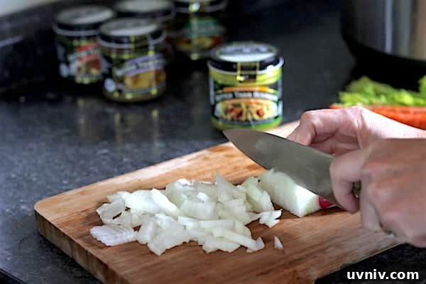 Image shows a hand chopping onions on a chopping board