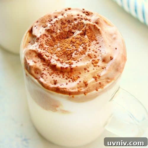 Hot chocolate with whipped topping in a glass.