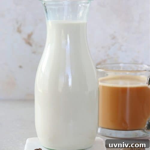 Creamer in a carafe on a marble coaster.