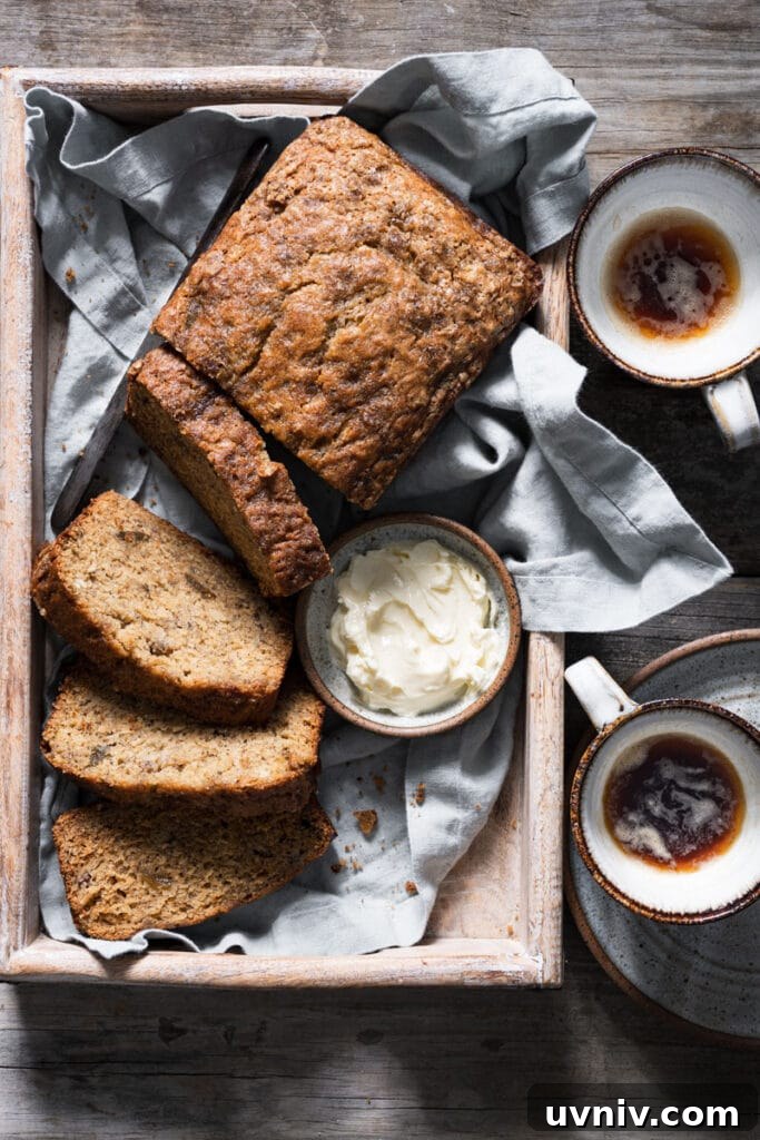 Irresistible Brown-Butter Banana Bread Recipe 2 Loaf of banana bread on a tray with slices cut.