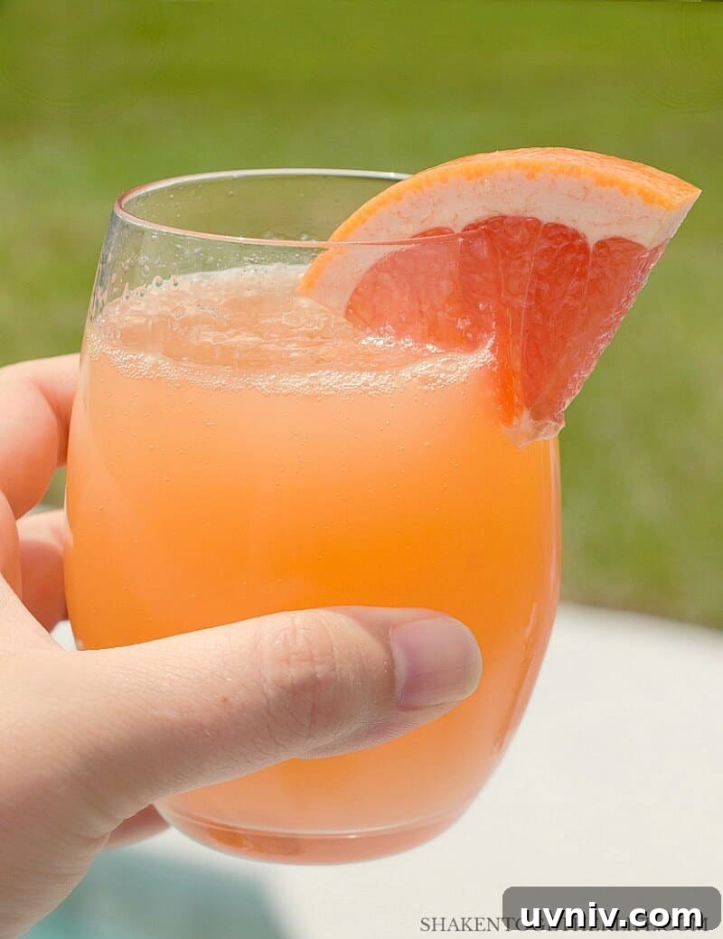 Ruby Red Grapefruit Mimosa with wedge of grapefruit garnish