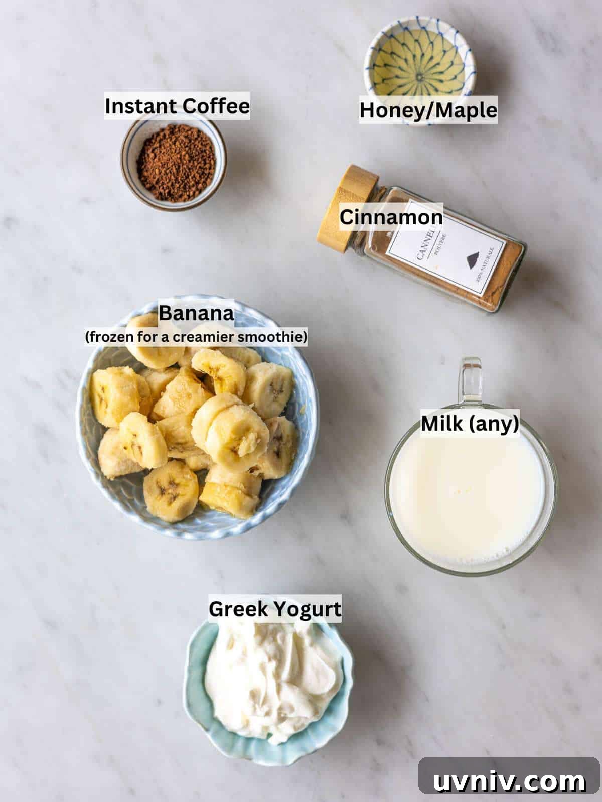 Iced Coffee Smoothie Recipe for a Morning Energy Boost 3 Ingredients for coffee smoothie on marble surface with bananas yogurt milk and coffee in natural light.