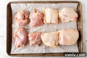 Juicy Smoked Chicken Thighs: Tender, Flavorful BBQ Recipe 18 raw chicken thighs on baking sheet