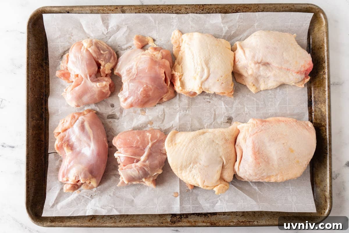Juicy Smoked Chicken Thighs: Tender, Flavorful BBQ Recipe 7 raw chicken thighs on baking sheet