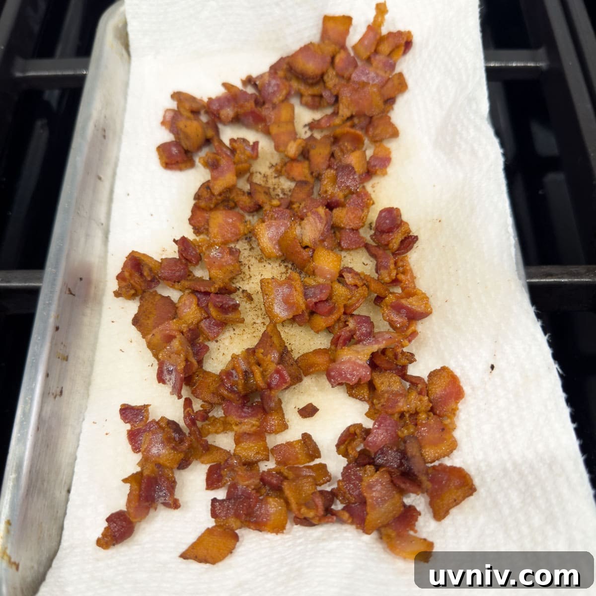 Draining crisply cooked bacon on paper towels.