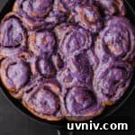 Cinnamon Rolls Made with Fluffy Challah Dough 7 Challah Dough cinnamon rolls with an ube cream cheese frosting all done and ready to be eaten! Overhead shot on a black background.