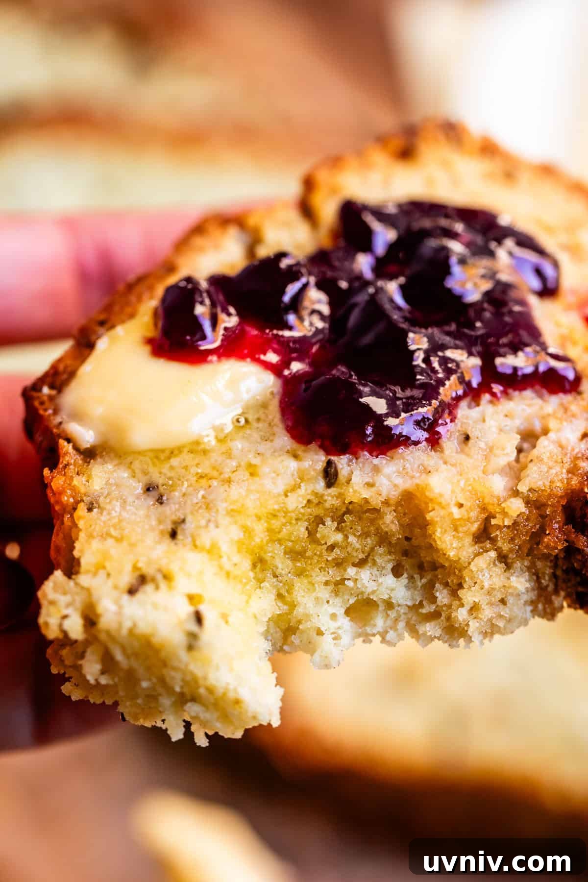 Authentic Irish Soda Bread Recipe You Can Make at Home 5 Close up of Irish soda bread with butter and blackberry jam spread on top.