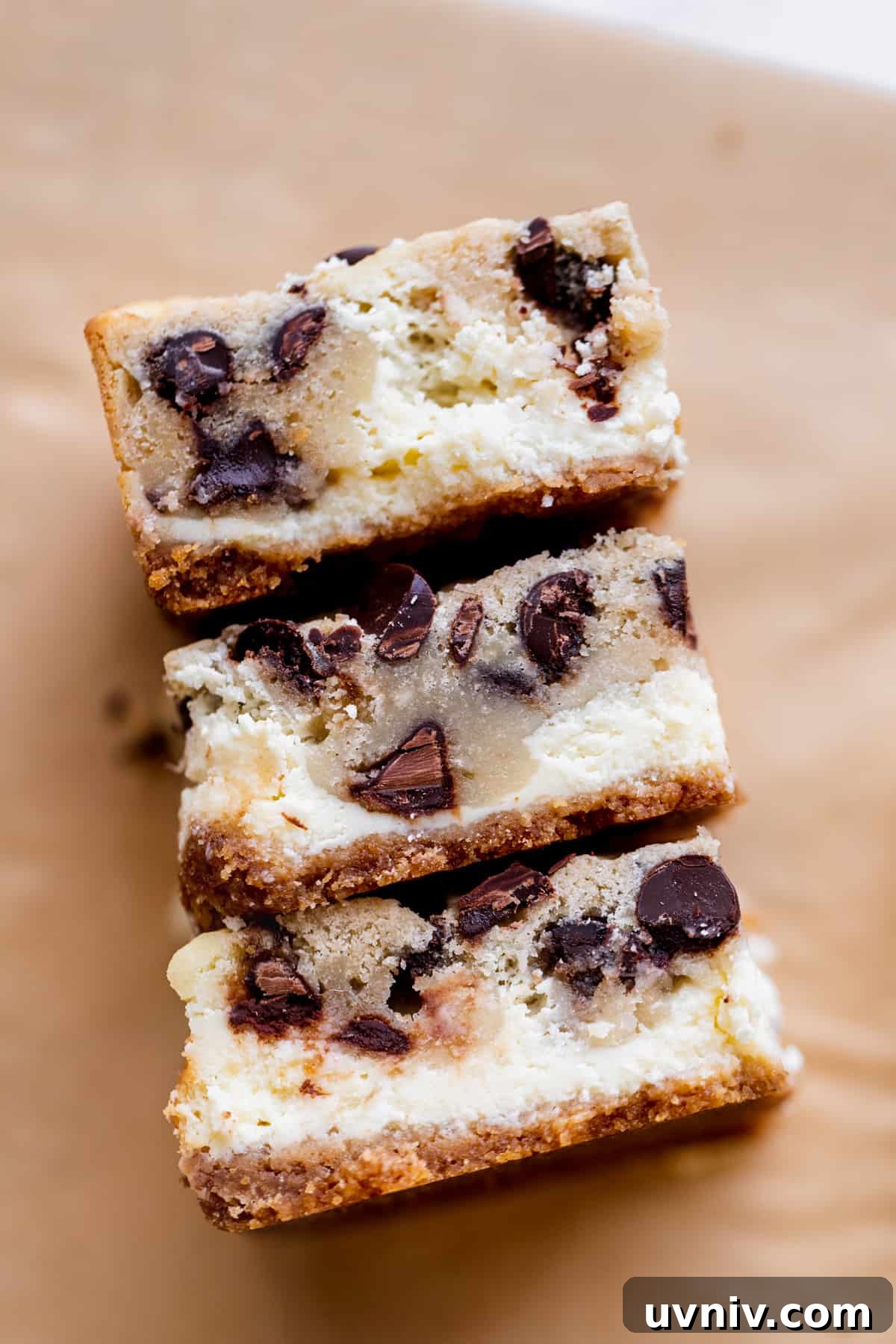 Cookie Dough Cheesecake Bars Recipe — No-Bake Dessert Bars 9 Three bars on their sides on parchment paper.