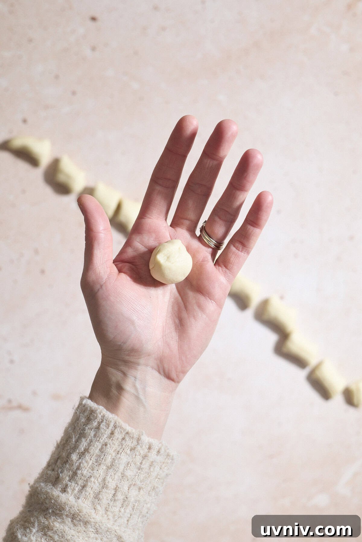 Dough rolled into a ball in the palm of a hand.