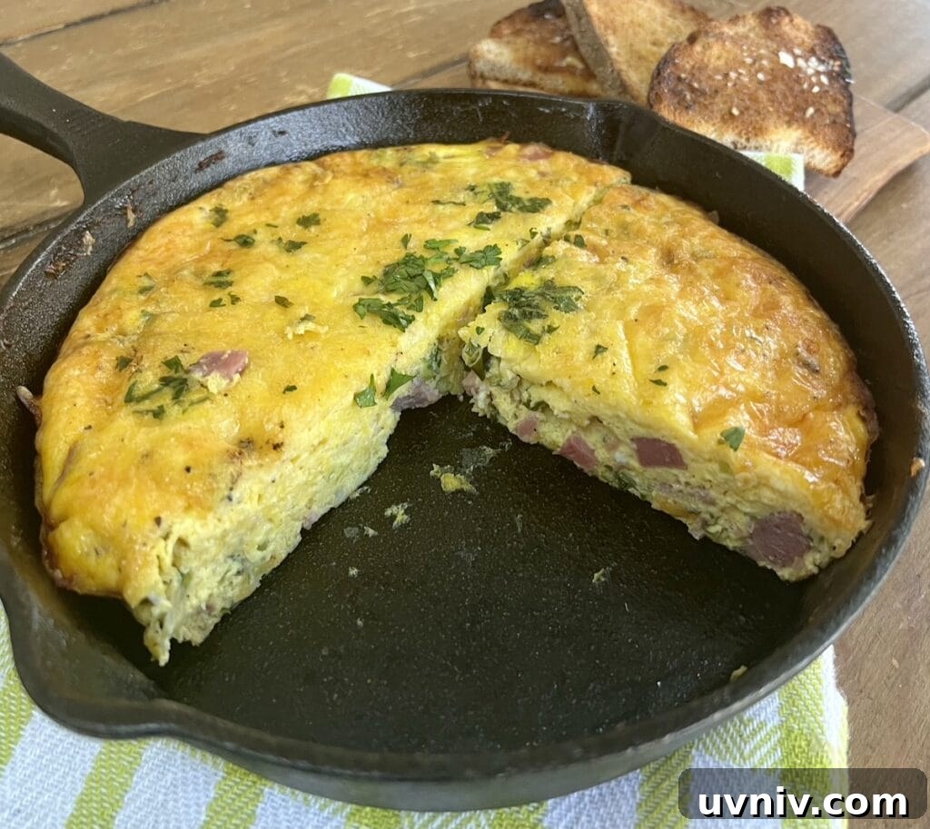 Frittata in cast iron pan with one slice removed.