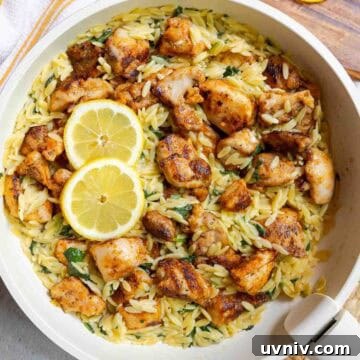 Lemon chicken orzo with diced chicken thighs and baby spinach in a large skillet.