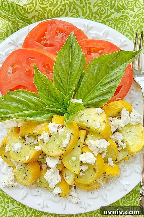 Crispy Air-Fried Summer Squash with Garlic and Parmesan 5 yellow squash topped with feta on a plate with sliced tomatoes and fresh basil