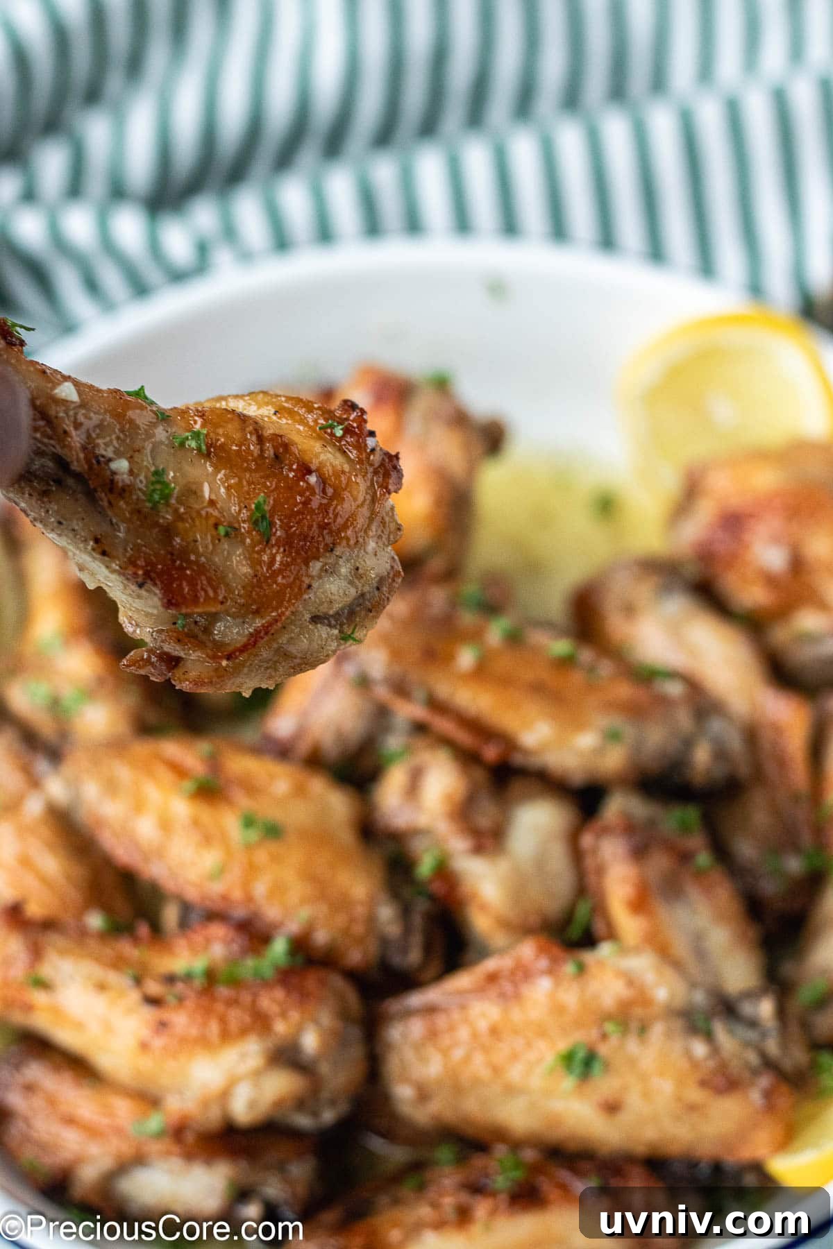 Crispy Garlic Butter Chicken Wings Recipe 3 Hand holding a chicken wing.