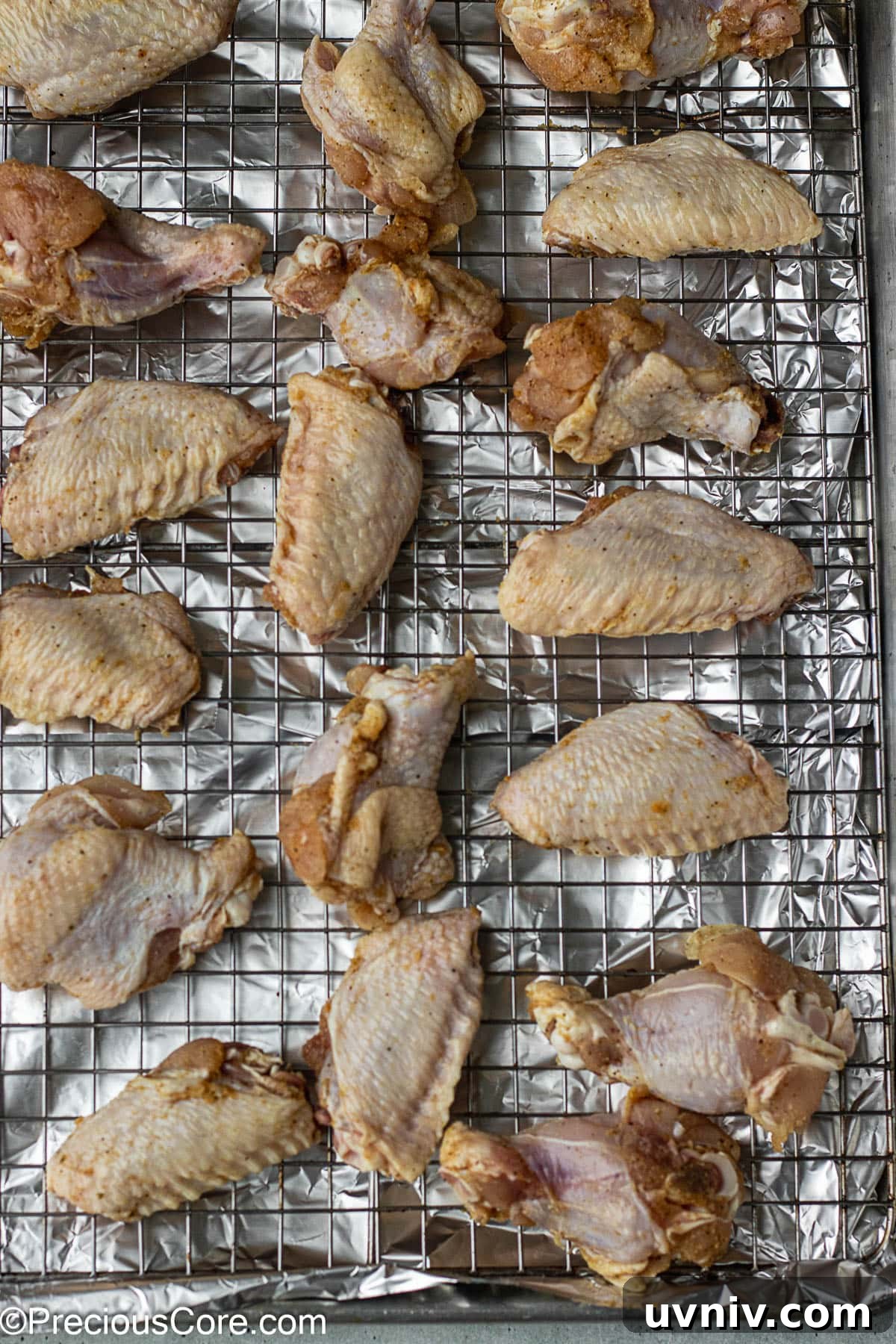 Crispy Garlic Butter Chicken Wings Recipe 6 Raw chicken on a rack placed on a baking sheet.