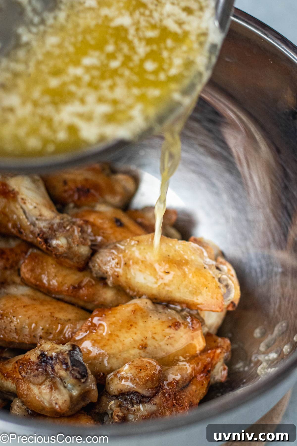 Crispy Garlic Butter Chicken Wings Recipe 8 Garlic butter sauce pouring into chicken.