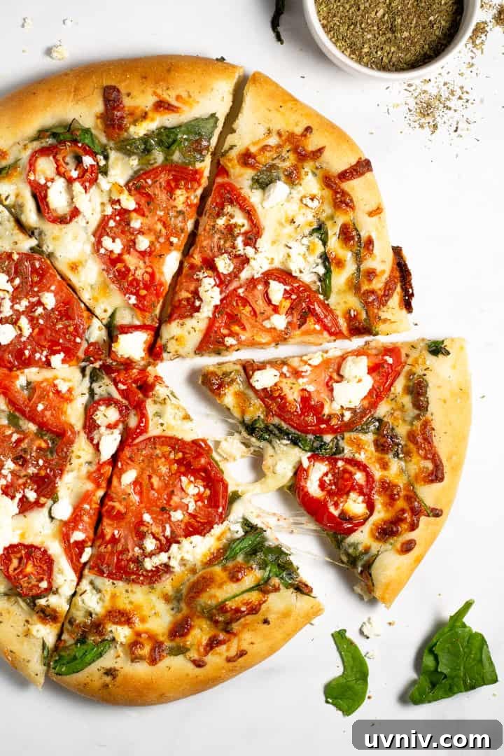 Over head shot of a tomato pizza on a white marble counter top 