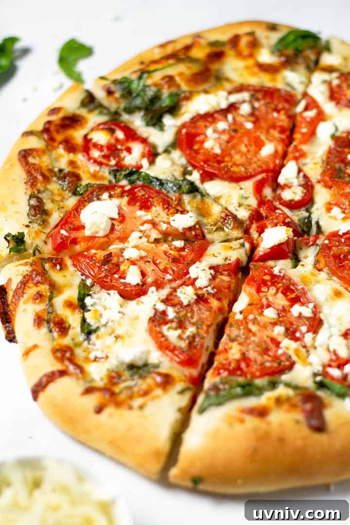 Close up shot of a tomato pizza on a white marble counter top 
