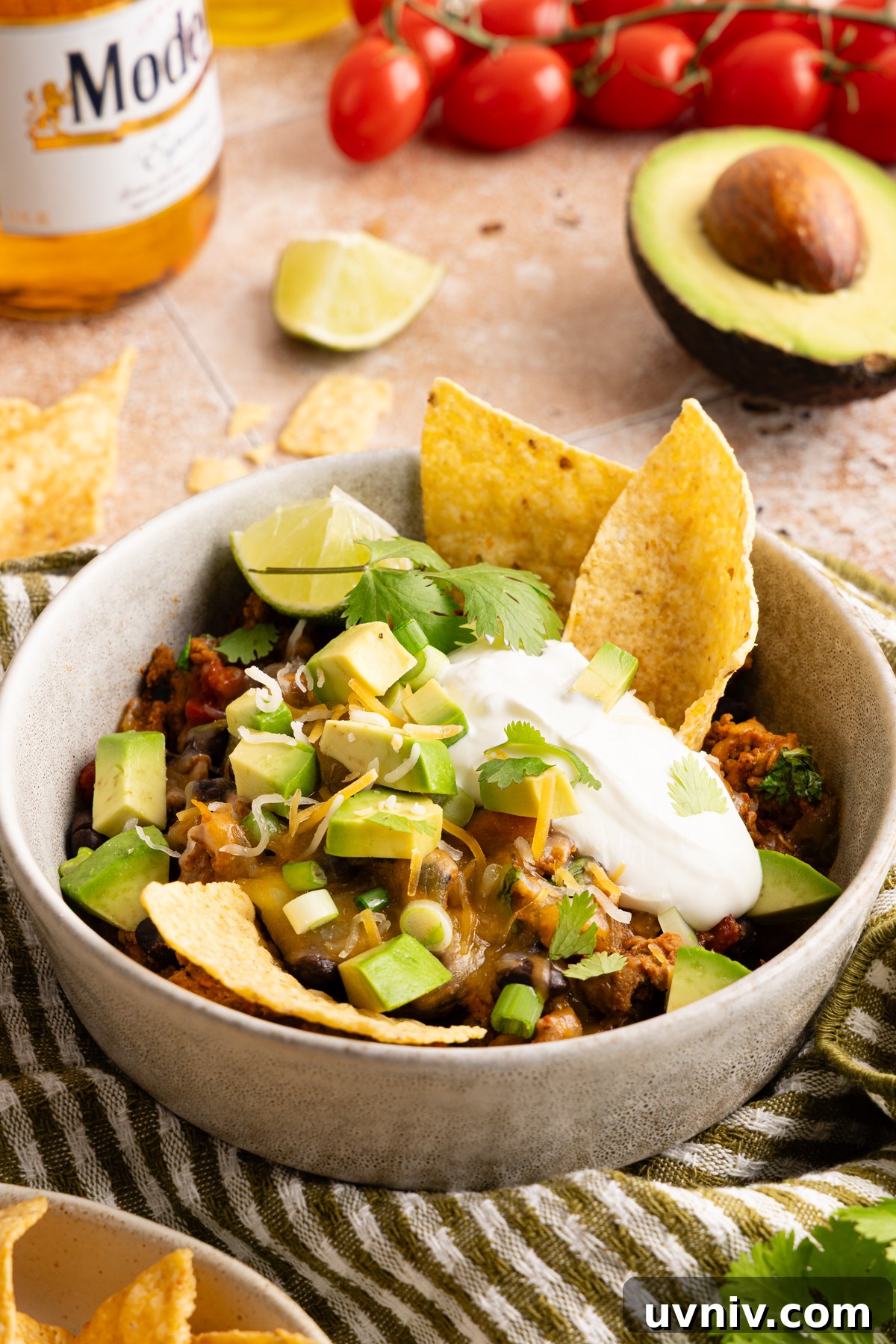 Cheesy Turkey Taco Skillet Dinner — One-Pan Weeknight Meal 13 A small serving bowl filled with a scoop of cheesy turkey taco skillet - garnished with sour cream, diced avocado, shredded cheese and served with tortilla chips