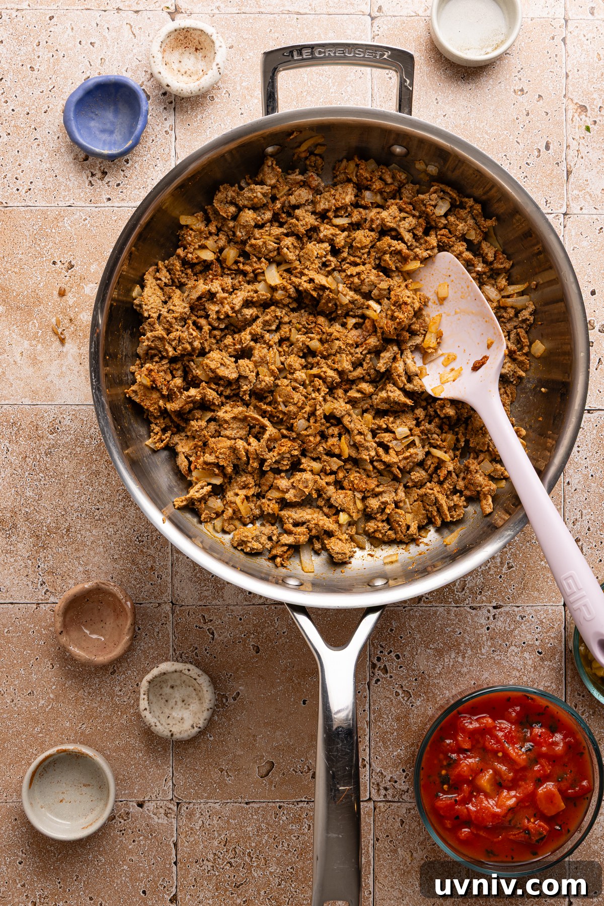 Cheesy Turkey Taco Skillet Dinner — One-Pan Weeknight Meal 6 A large skillet filled with taco seasoned and cooked ground beef and onions sitting next to a small bowl of canned diced tomatoes