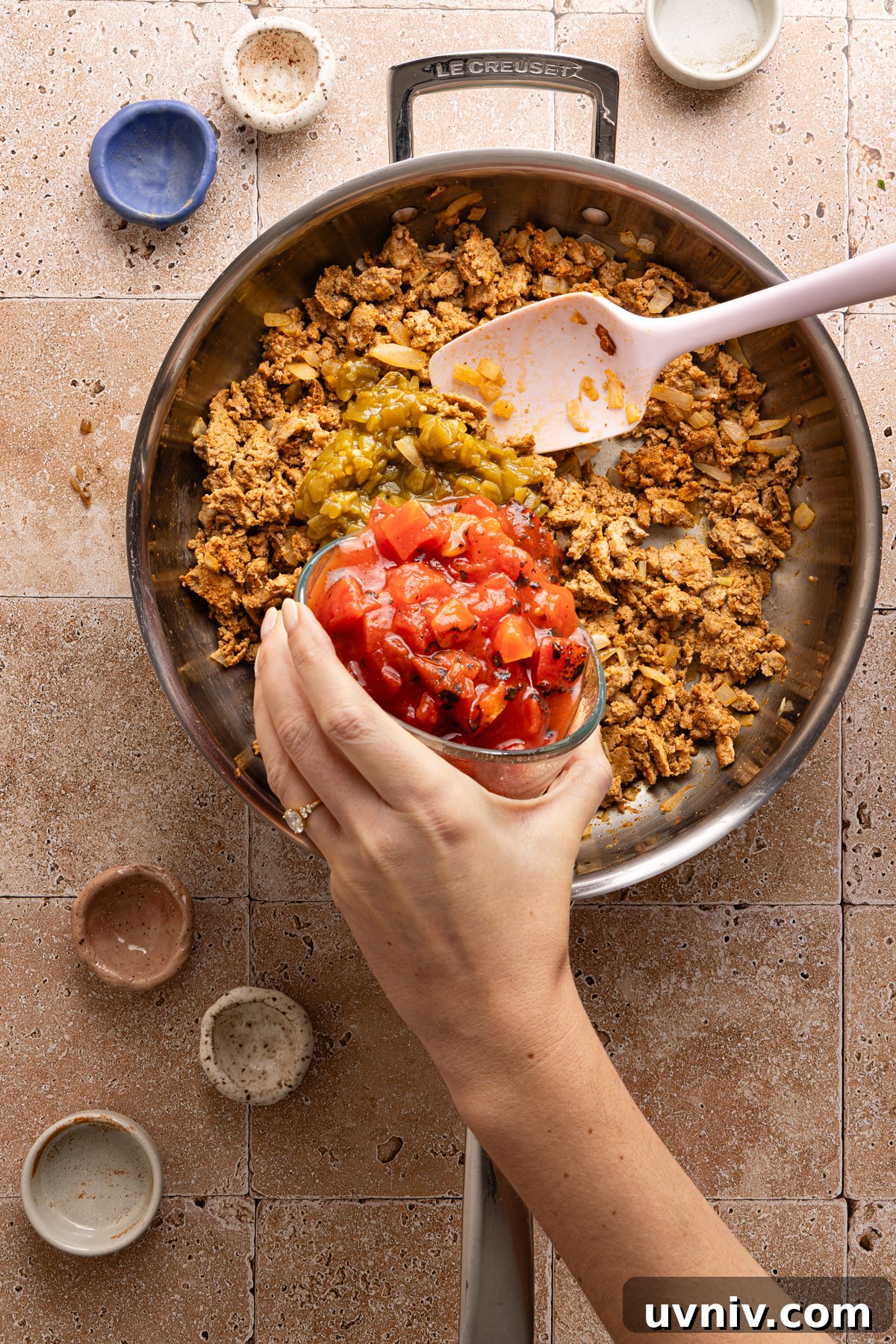 Cheesy Turkey Taco Skillet Dinner — One-Pan Weeknight Meal 7 Canned diced tomatoes and canned green chiles being poured into a large skillet filled with cooked ground turkey