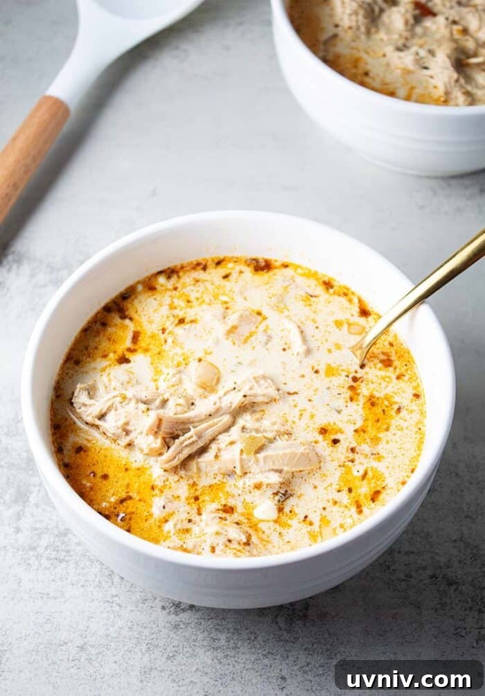 Low-Carb White Chicken Chili Recipe for Keto Diet 10 overhead view of best healthy keto white chicken chili in white serving bowl and gold serving spoon