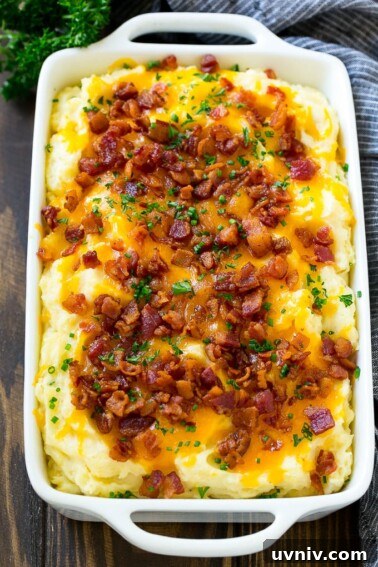 Loaded mashed potato casserole topped with melted cheese, bacon and herbs.