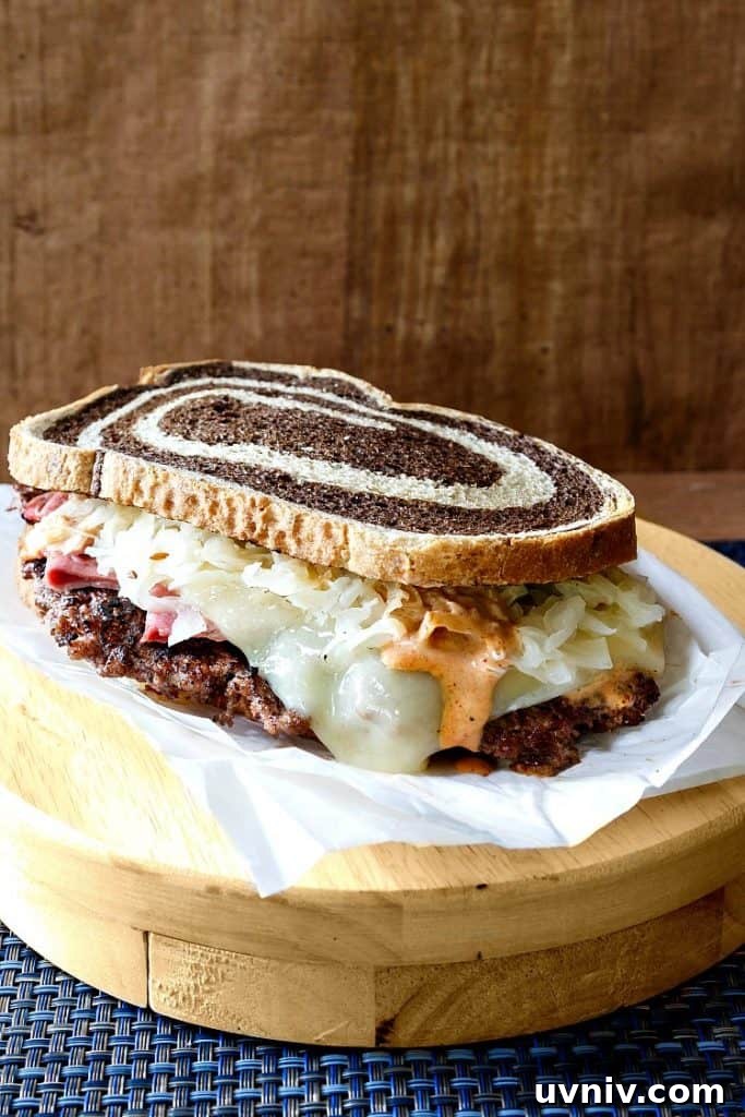 Smashed Reuben Burger: Corned Beef, Sauerkraut & Melty Swiss 3 Reuben burger on marble rye with a rustic presentation.