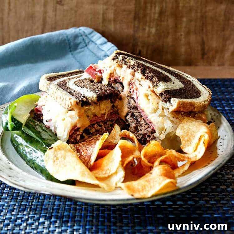 Smashed Reuben Burger: Corned Beef, Sauerkraut & Melty Swiss 4 A smashed Reuben burger on a plate with chips and pickle spears.