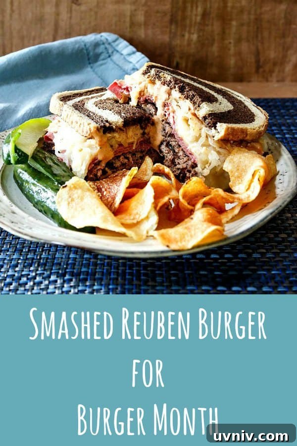 Smashed Reuben Burger photo of smashed reuben burger with pickle spears and potato chips on a plate on a blue placemat.