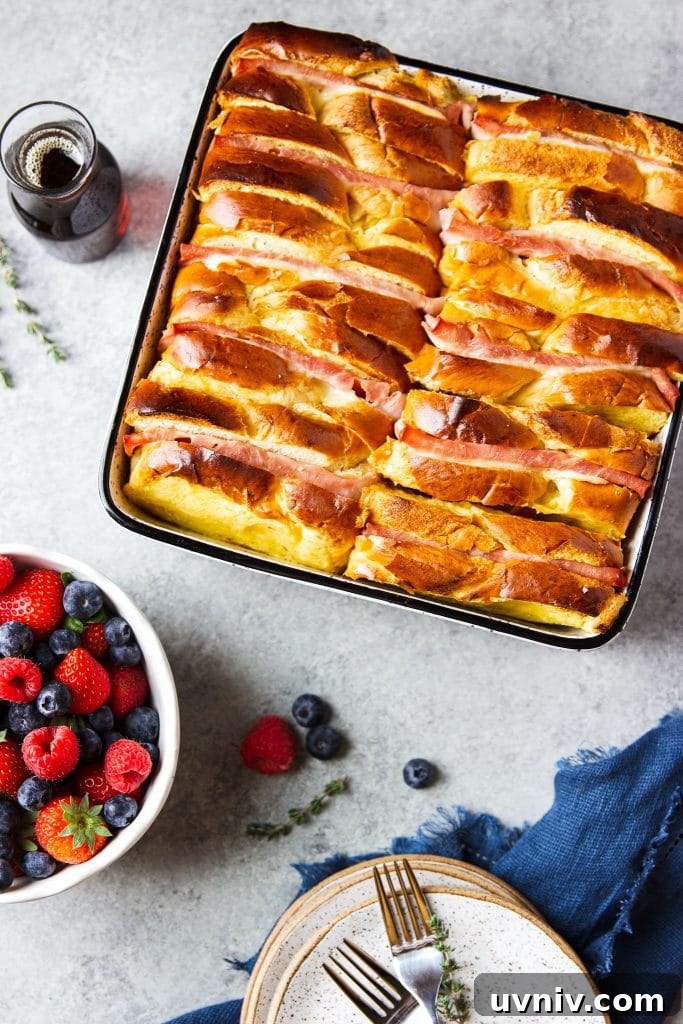 Ham and Cheese Breakfast Casserole Recipe for Brunch and Meal Prep 5 Ham and Cheese Breakfast Casserole served with warm syrup and a side of blueberries, raspberries and strawberries, blue dish towel