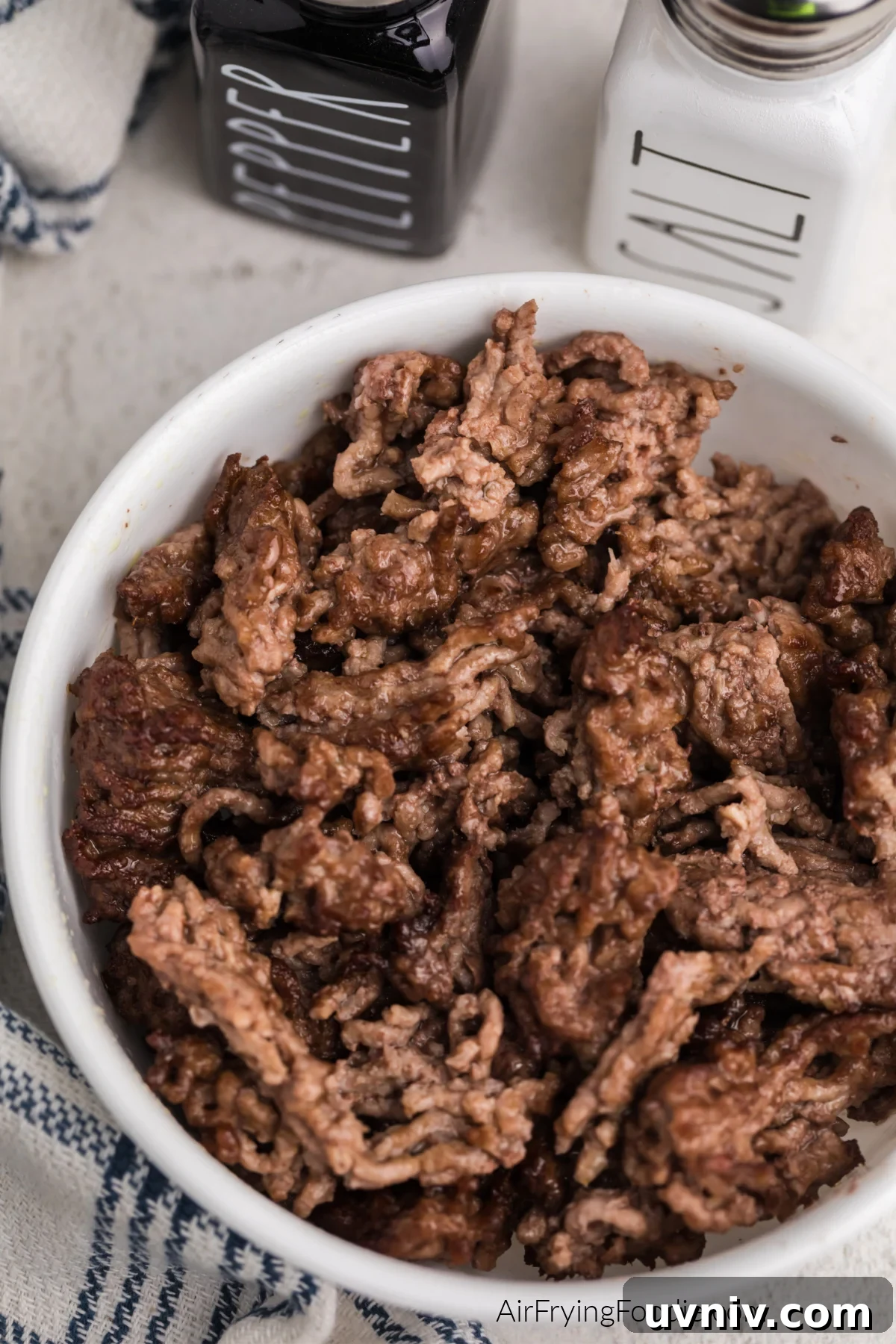 Close up photo of air fried ground beef in a white bowl.