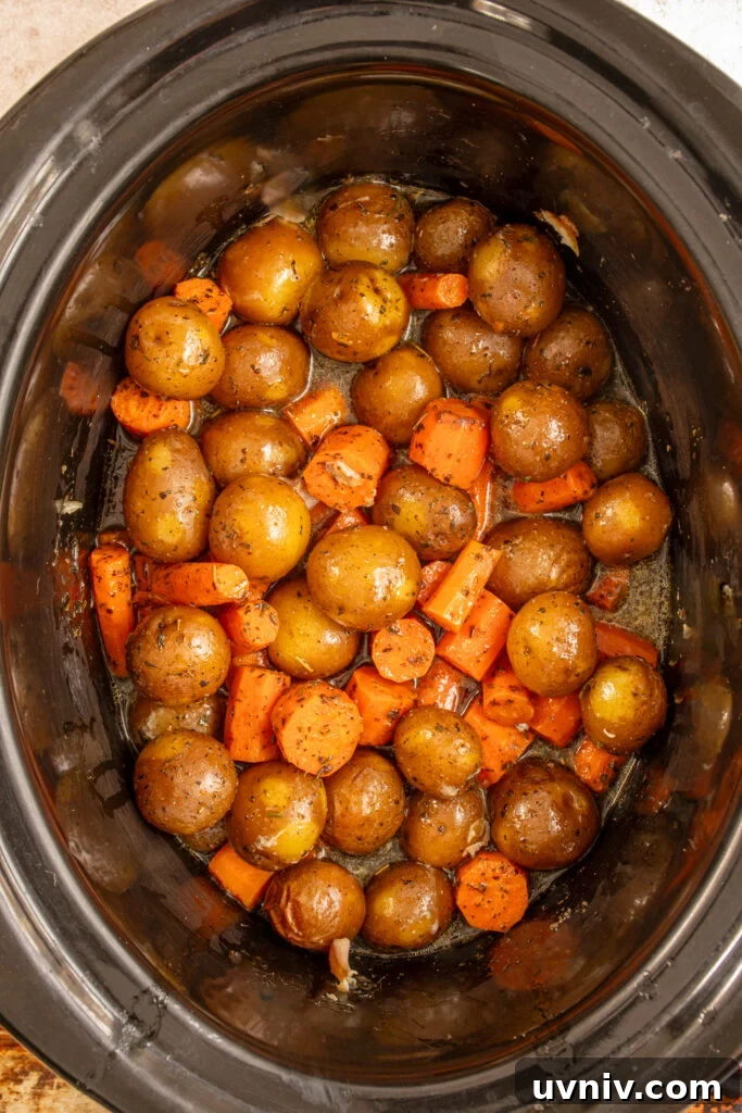 Slow Cooker Chicken Legs with Crispy Potatoes Recipe 11 Cooked carrots and baby potatoes in a crockpot.