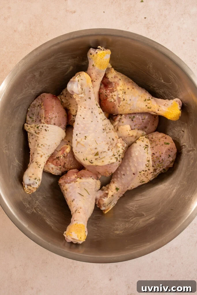 Slow Cooker Chicken Legs with Crispy Potatoes Recipe 7 Seasoned chicken legs in a mixing bowl.