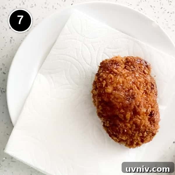 A Japanese fried menchi pattie draining on paper towel.