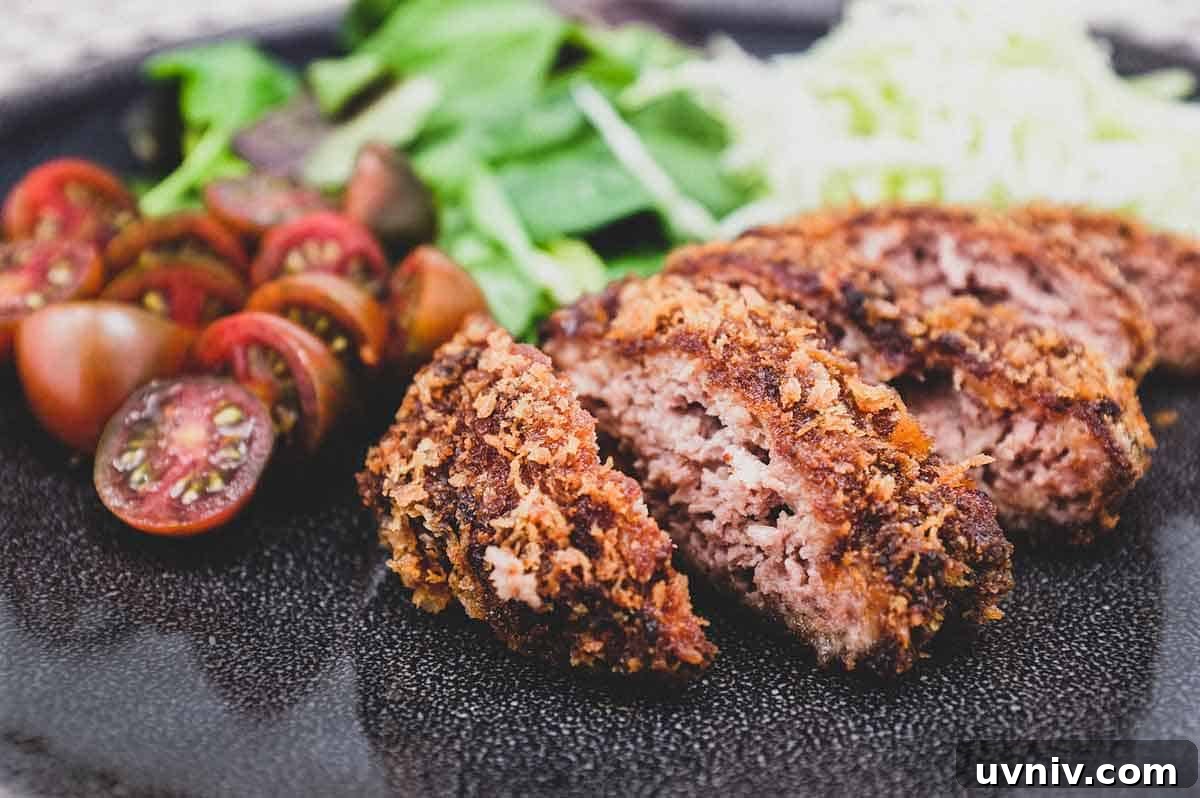 Menchi katsu and a small salad with shredded cabbage sit on a plate