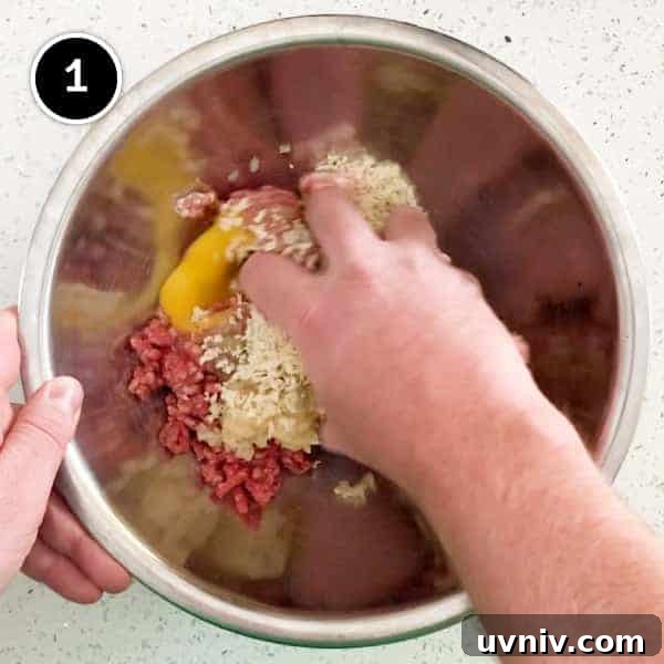 Mixing together pork and beef in a small bowl by hand.