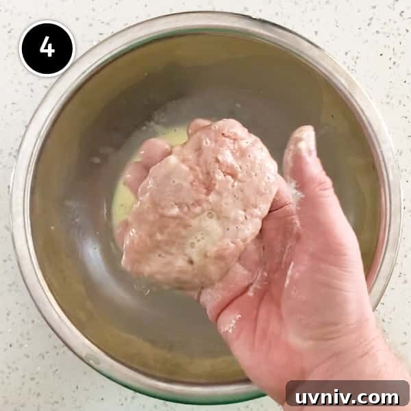 Coating a Japanese menchi pattie with egg