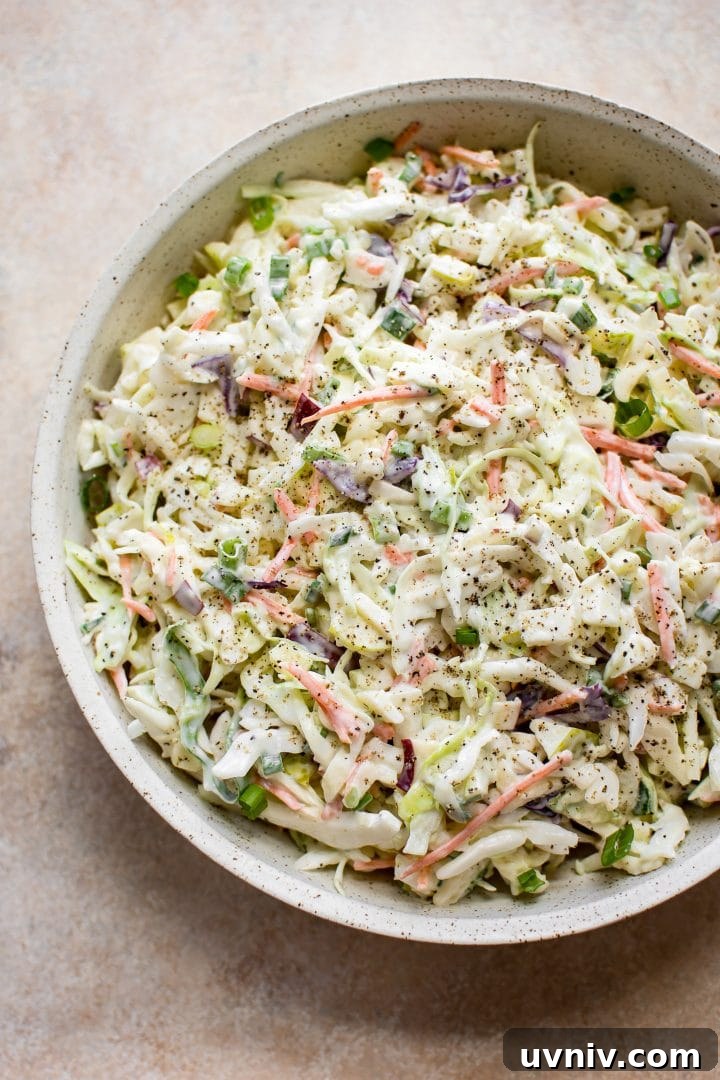 Crisp Apple Slaw Recipe with Tangy Honey-Mustard Dressing 2 simple apple, cabbage, and carrot slaw in a beige bowl